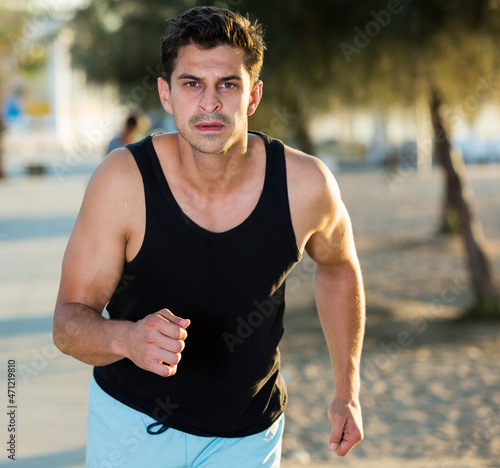 Sporty man during morning running training outdoors