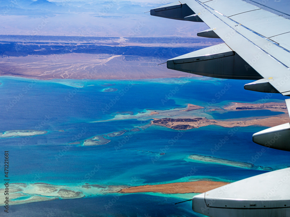 Aerial view above the clouds and sky, Inspiration concept. Travel freedom by air. Flight, view from the airplane to tropical sea with corals. Turbo-jet aircraft engine, transport 4k. Passenger airbus Aerial view above the clouds and sky, Inspiration concept. Travel freedom by air. Flight, view from the airplane to tropical sea with corals. Turbo-jet aircraft engine, transport 4k. Passenger airbus
