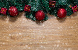 Christmas and Holiday background with fir tree and red christmas decorations on wood background with  snow falling over