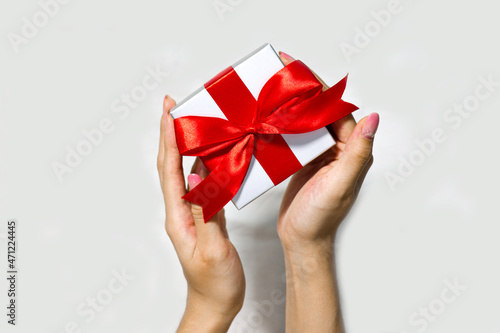 Woman's hands holding Christmas gift box on white background. Christmas and Holiday background concept