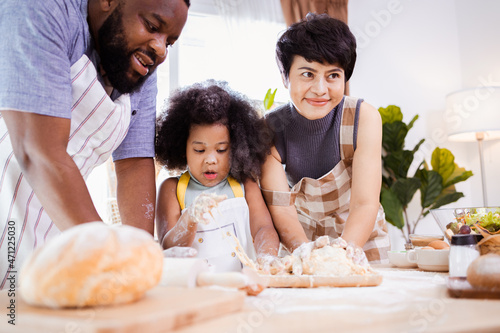 Happy African American family enjoy together while prepare the flour for making cookies at home