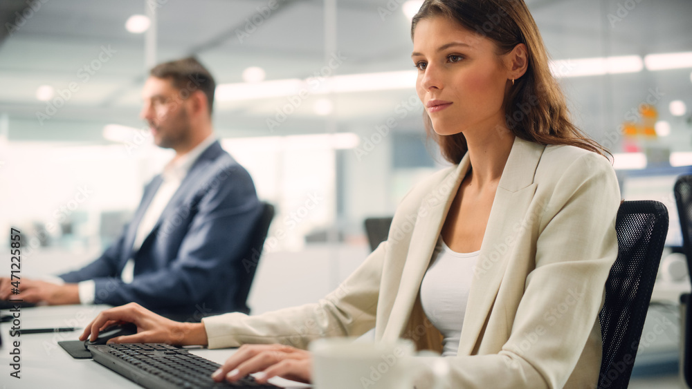 Young Confident Businesswoman Using Desktop Computer in Modern Office with Colleagues. Stylish Beautiful Manager Working on Commercial, Financial and Marketing Projects. Specialist in Diverse Team. Young Confident Businesswoman Using Desktop Computer in Modern Office with Colleagues. Stylish Beautiful Manager Working on Commercial, Financial and Marketing Projects. Specialist in Diverse Team.