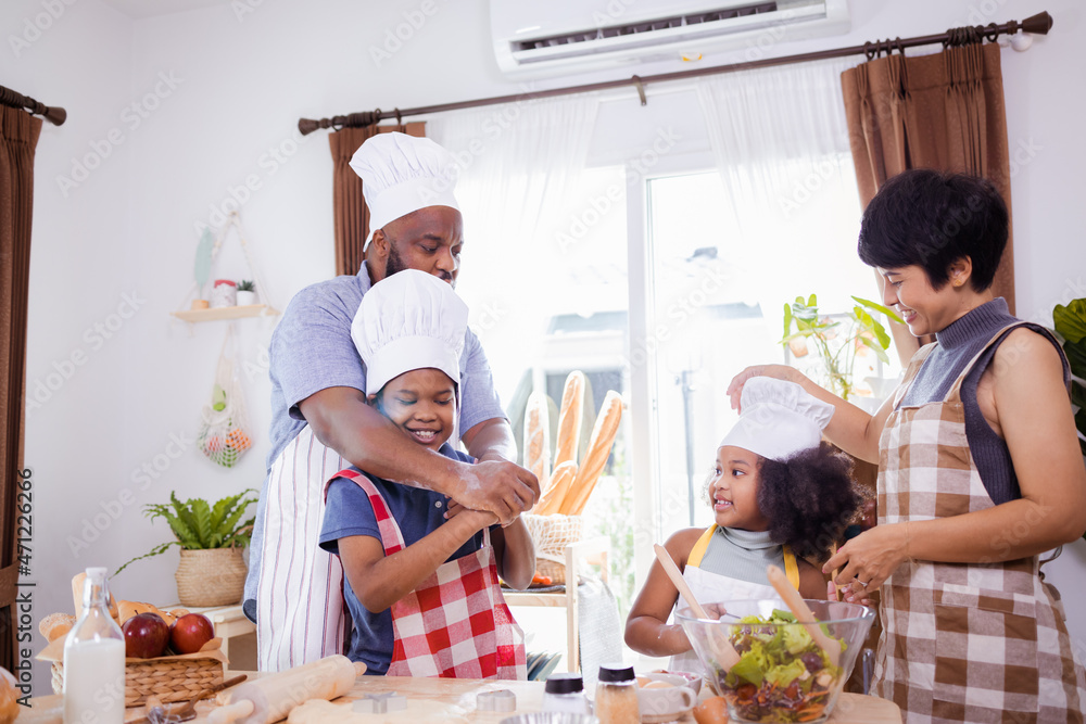 Happy African American family enjoy together while preparing the flour for making cookies at home. African American family concept
