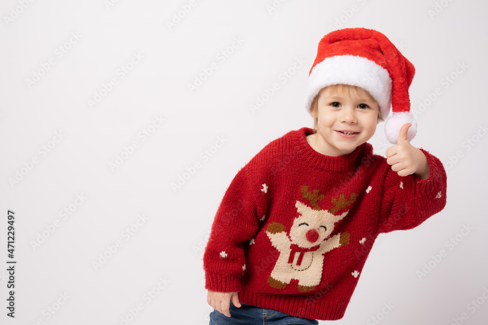 Cute little boy wearing santa hat with thumb up standing isolated over white background. Cute little boy wearing santa hat with thumb up standing isolated over white background.