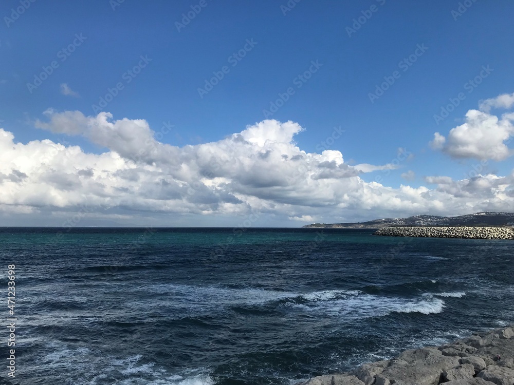 Scenic white clouds of type cumulus over dark blue colored ocean sea