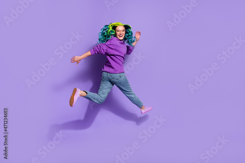 Full length photo of cheerful blue shine haired lady jump run empty space discount isolated over purple color background