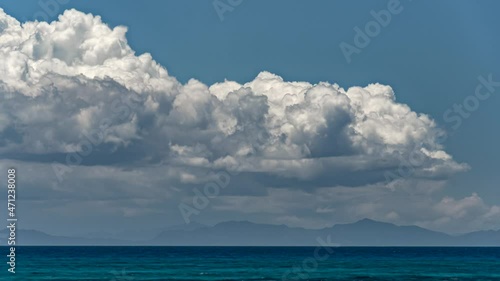 Wallpaper Mural Huge cumulus clouds roll, form and dissipate over the ocean with a mountainous shoreline in the background - wide angle time lapse Torontodigital.ca