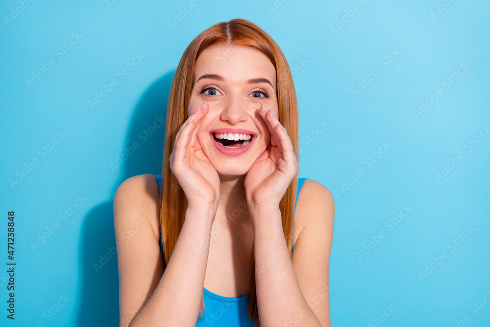 Photo of shiny excited young lady dressed bodysuit top arms lips making announcement isolated blue color background Photo of shiny excited young lady dressed bodysuit top arms lips making announcement isolated blue color background