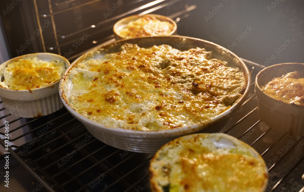 Homemade creamy Au Gratin Potatoes in oven. Homemade creamy Au Gratin Potatoes in oven.
