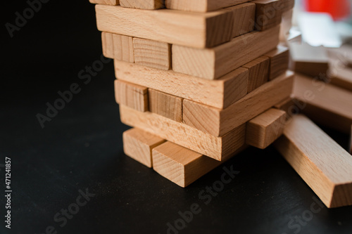 Jenga game. Take out small wooden blocks. Leisure time concept at home