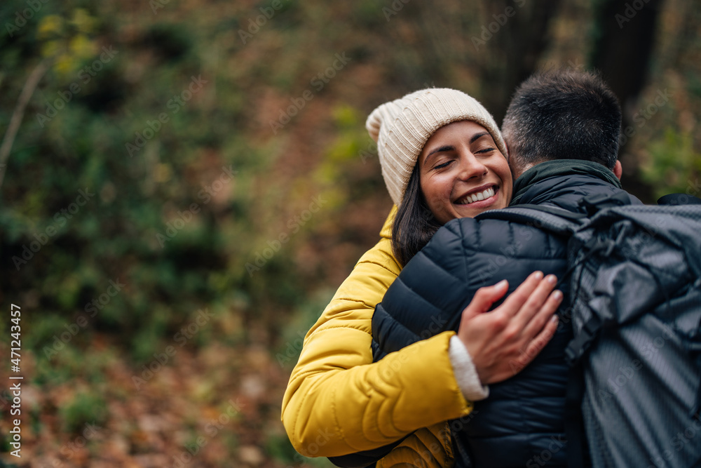Happy caucasian woman, hugging her husband, while hiking.