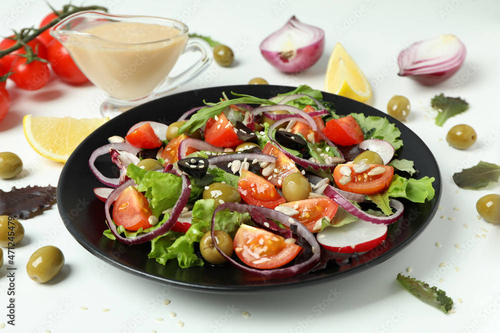 Concept of tasty food with vegetable salad with tahini sauce on white background