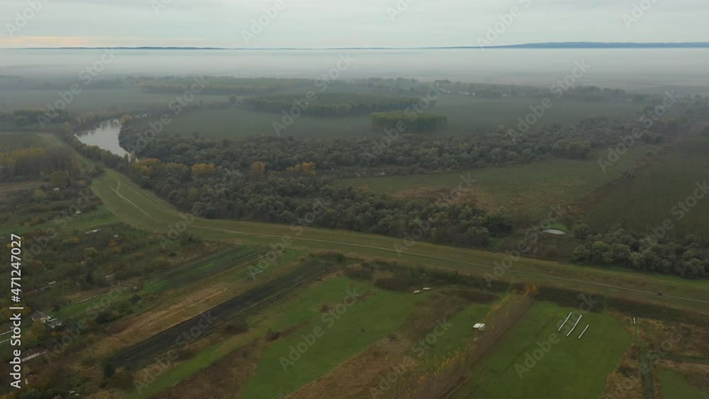 Above top view, forward dolly moving, over grassy landscape, forest and vegetation, embankment with dirty road, meadow. Above top view, forward dolly moving, over grassy landscape, forest and vegetation, embankment with dirty road, meadow.