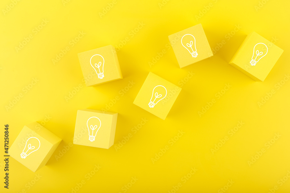Concept of idea, creativity, start up or brainstorming. Light bulbs drawn on yellow toy cubes on yellow background Concept of idea, creativity, start up or brainstorming. Light bulbs drawn on yellow toy cubes on yellow background