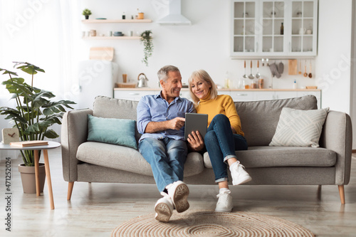 Fotografi Cheerful Mature Spouses Using Digital Tablet At Home