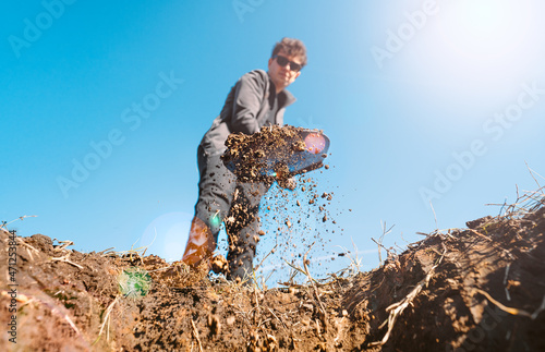 Man digging a hole in the ground with a shovel photo