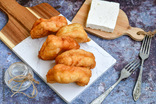 Traditional Bulgarian home made deep fried  patties  covered with sugar  оn rustic backgroud.Mekitsa or Mekica,  on wooden  rustic  background. Made of kneaded dough that is deep fried  photo