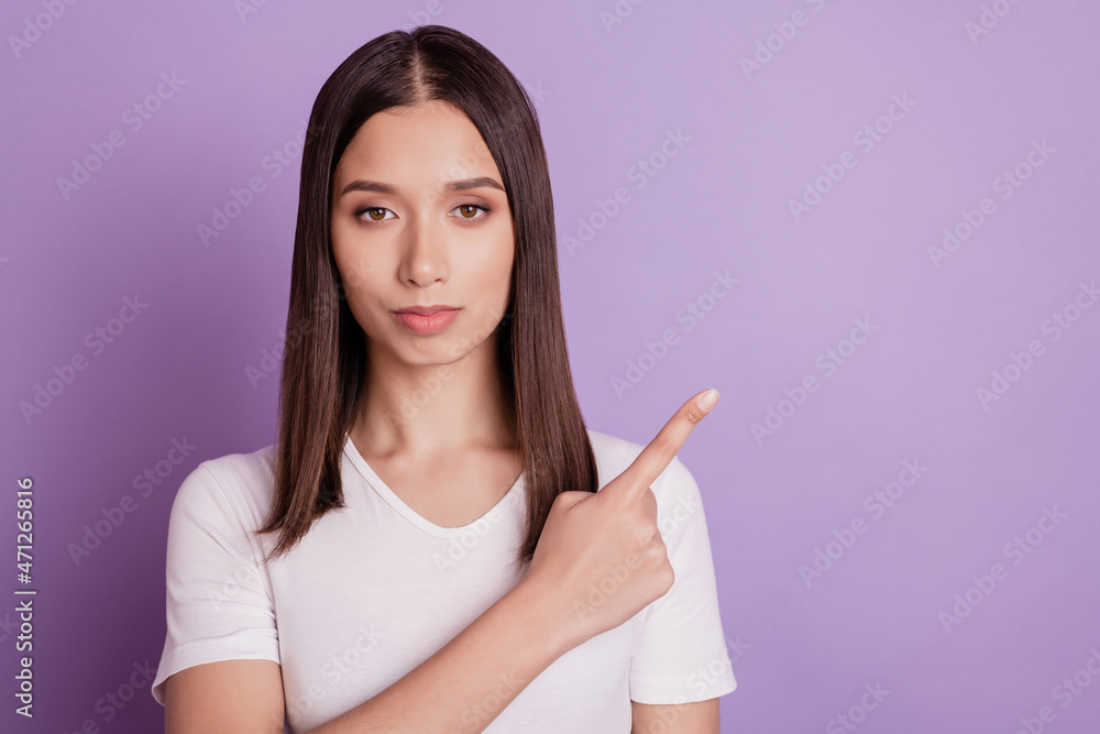 Photo of young girl point finger empty space ad advice choice decision solution isolated on violet color background Photo of young girl point finger empty space ad advice choice decision solution isolated on violet color background
