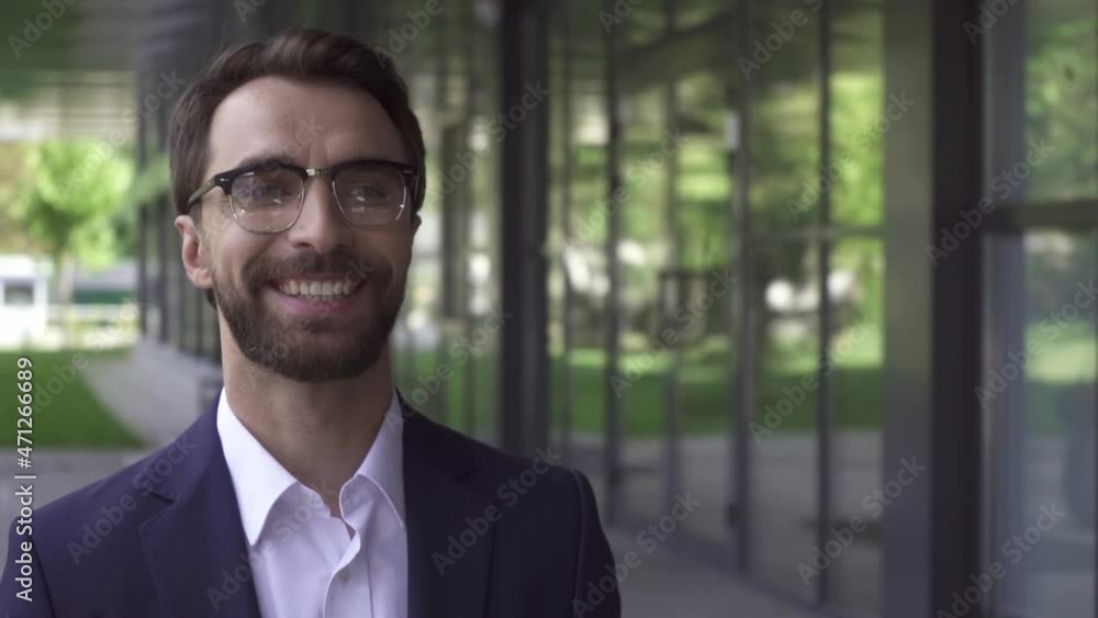 Slow motion of cheerful businessman walking near building outdoors Slow motion of cheerful businessman walking near building outdoors