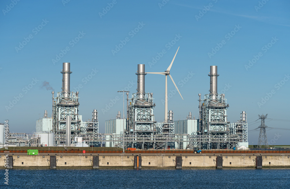 Modern multi-fuel power station and a wind turbine in a seaport.