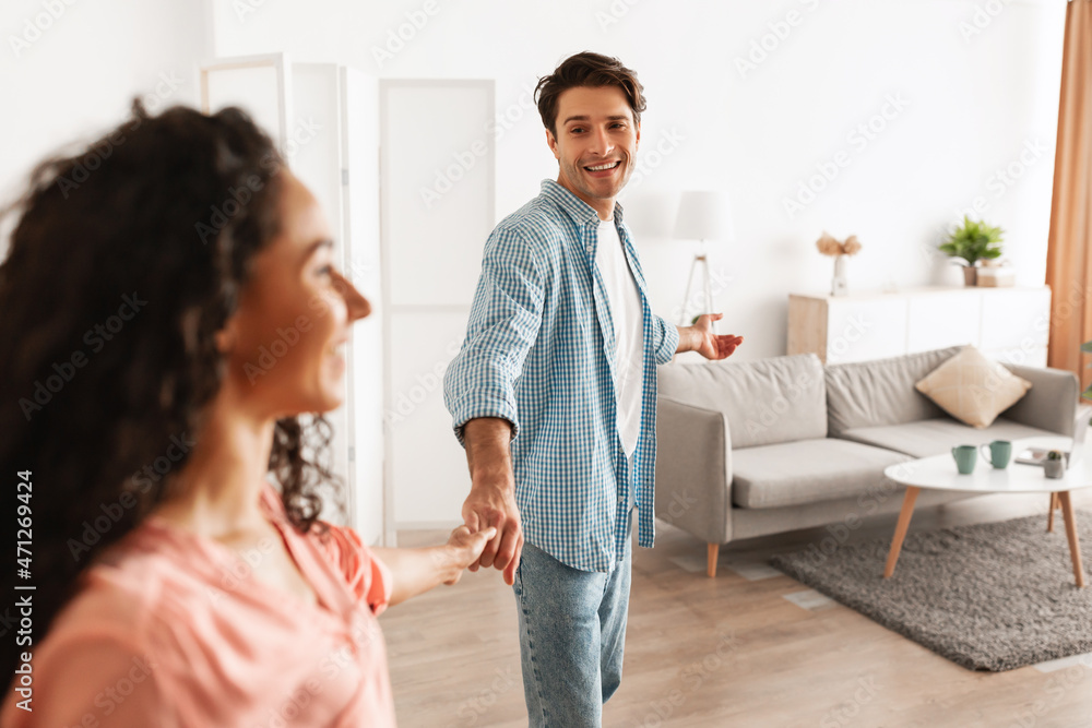 Fototapeta premium Happy guy inviting lady to enter home