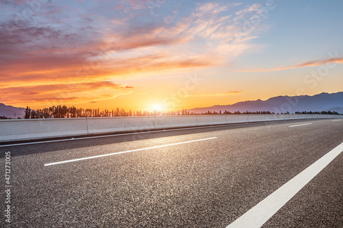 Empty asphalt road and mountain scenery at sunrise © ABCDstock