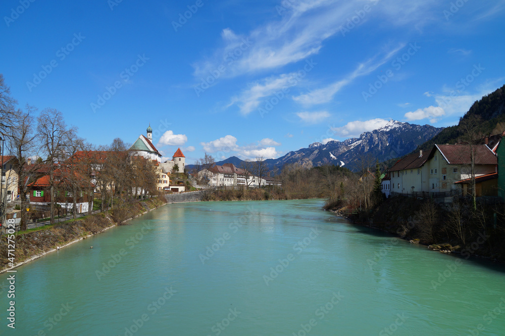 old German town Fussen on the turquoise Lech river with the snowy Alps in the background in the middle of March (Bavaria, Germany)