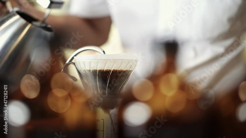 barista pour hot water to ground coffee on dripper, coffee brewing process