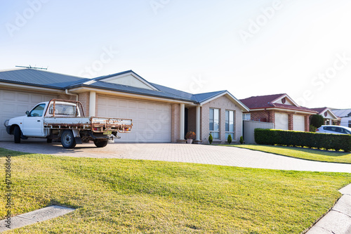 Ute parked in driveway of house in nice neighbourhood photo
