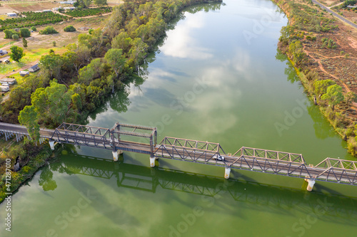 Aerial view of a metal span bridge over a wide green river photo