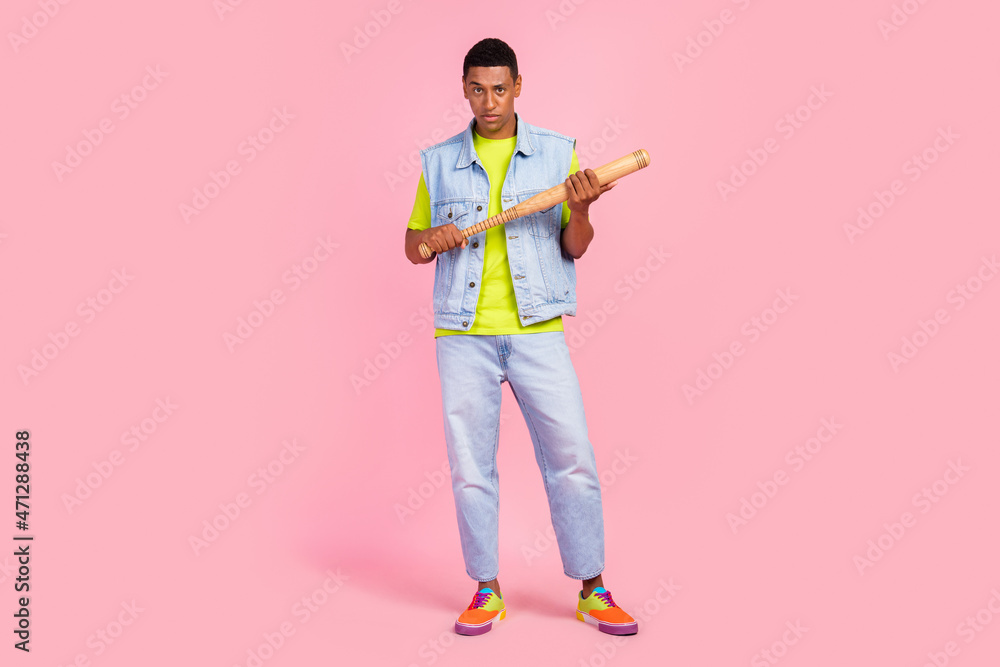 Full body photo of mad millennial brunet guy hold bit wear t-shirt vest jeans footwear isolated over pink color background Full body photo of mad millennial brunet guy hold bit wear t-shirt vest jeans footwear isolated over pink color background