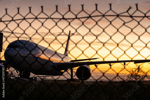A parked plane behind a fence at the Brisbane domestic airport photo