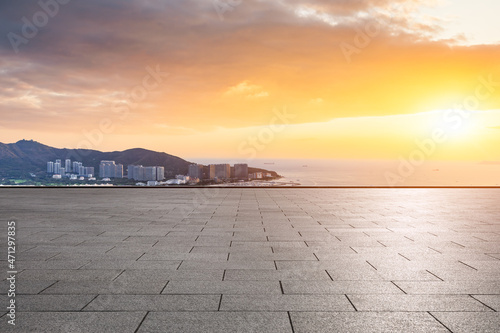 Empty square floor and modern city buildings with skyline by the sea