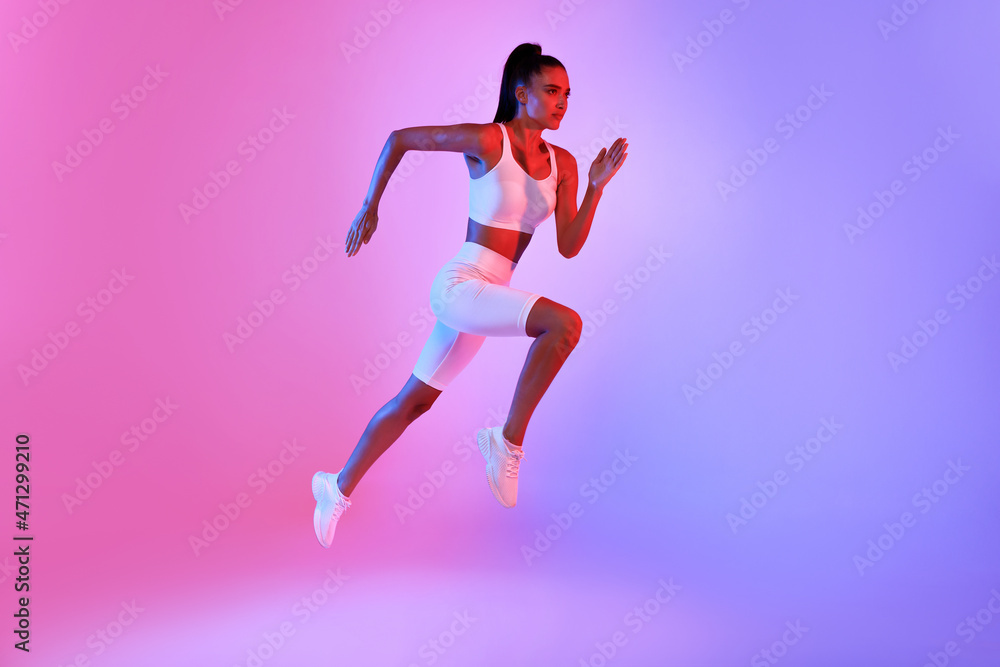Fitness Lady Jumping Running In Mid-Air Over Neon Background