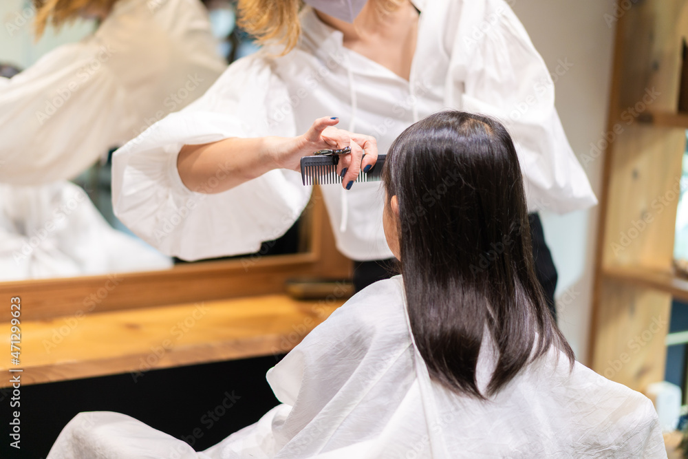 Obraz premium 美容室でヘアカットをする女の子