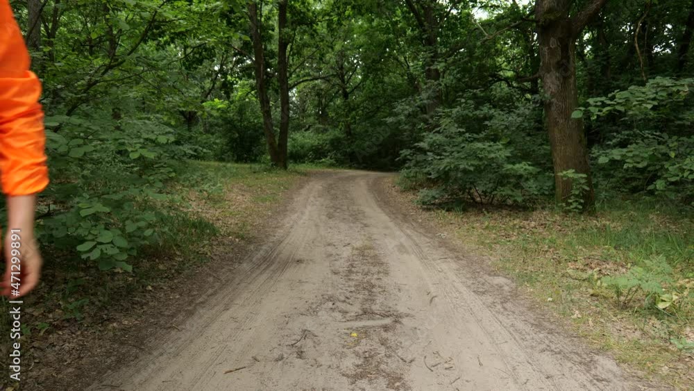 Young blonde woman in an orange tracksuit in a pinch on the road near the forest Young blonde woman in an orange tracksuit in a pinch on the road near the forest
