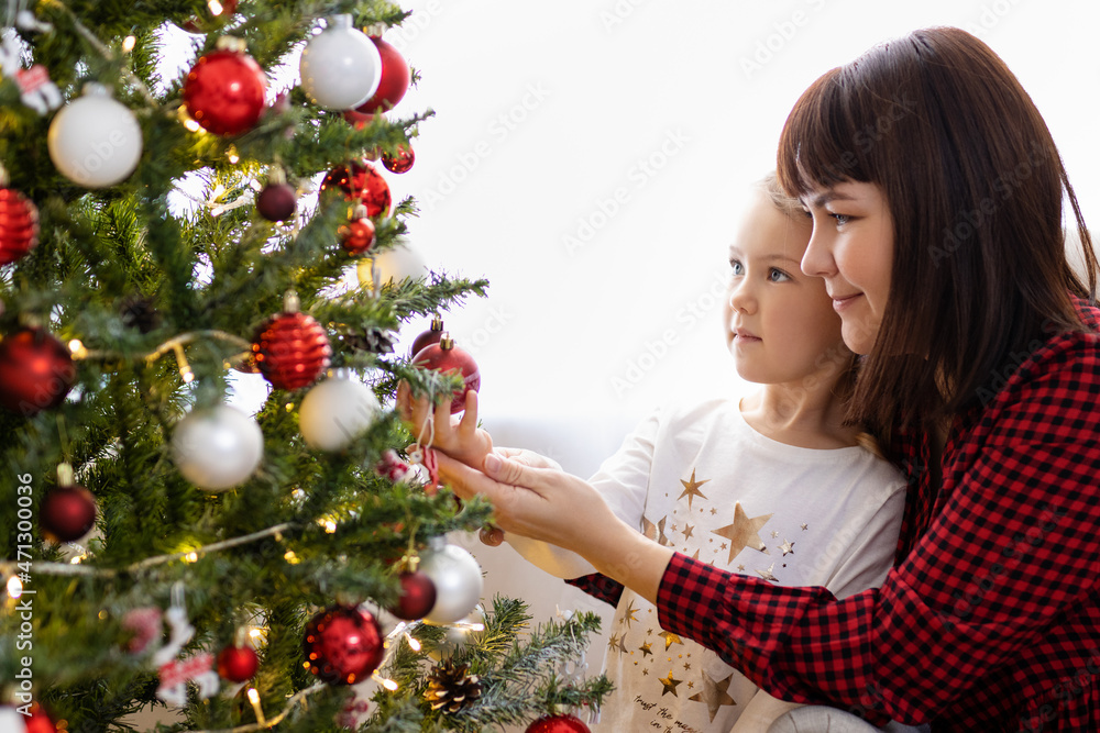 Cute mother and daughter decorated Christmas tree