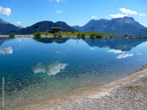 Die Loferer Steinberge spiegeln sich im klaren Wasser eines Sees.