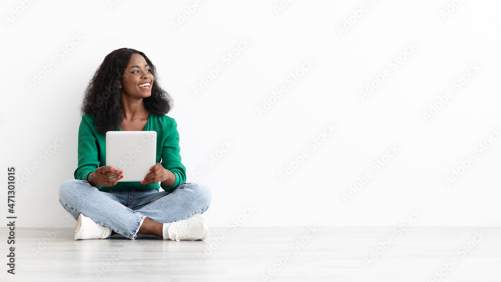 Happy black woman with tablet looking at empty space Happy black woman with tablet looking at empty space