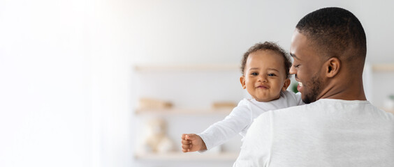 Baby Insurance. Young Black Father Holding Cute Smiling Infant Child On Hands
