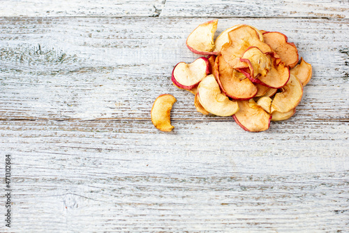 A pile of dried apples in slices on a white wooden background. Dried fruit chips. Healthy food