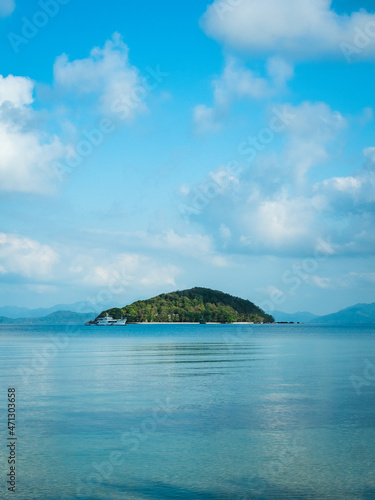 Scenic view of Koh Kham Island in the middle of peaceful bay against cloudy blue sky. Shot from Koh Mak Island, Trat, Thailand. Minimal background.
