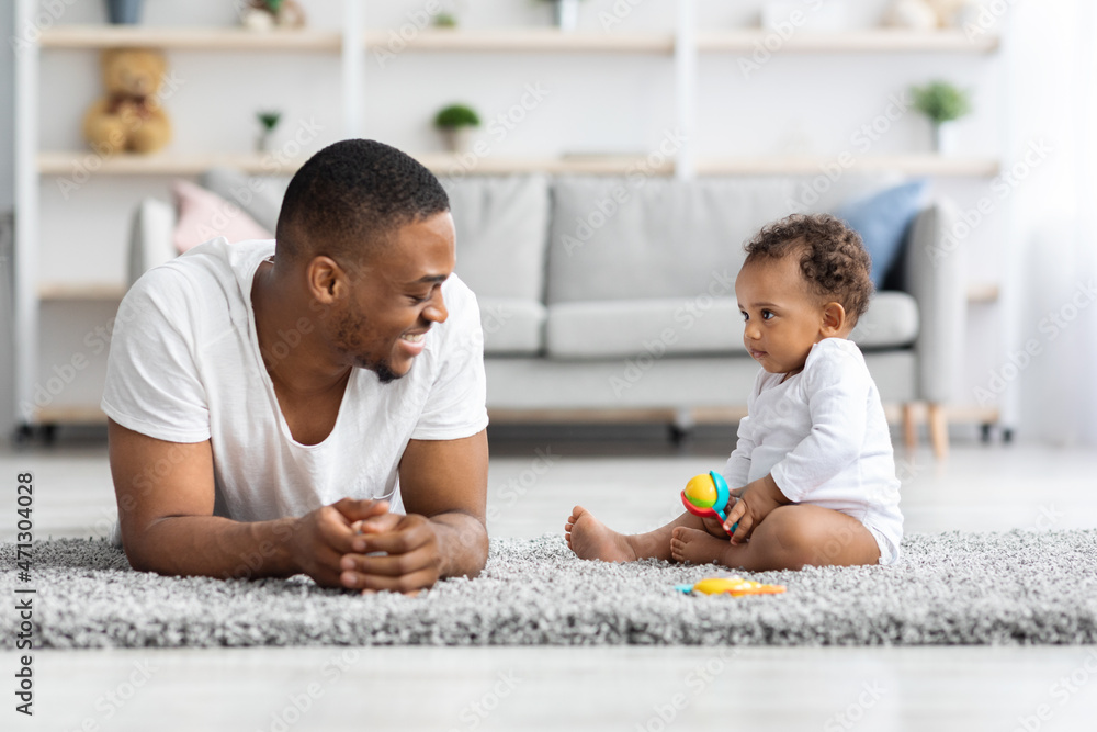 Fototapeta premium Young Happy African American Dad Playing With Cute Infant Baby At Home