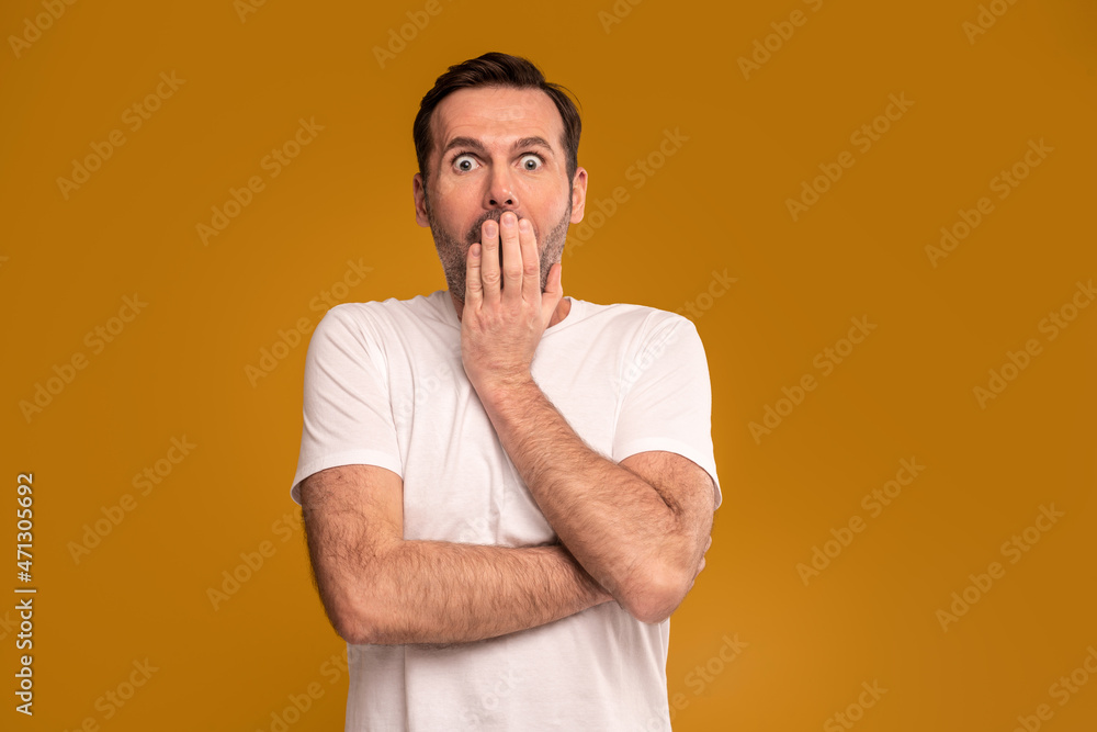 Handsome man with surprised emotions on his face looking at the camera. A lot of copy space. Facial expressions concept. Handsome man with surprised emotions on his face looking at the camera. A lot of copy space. Facial expressions concept.