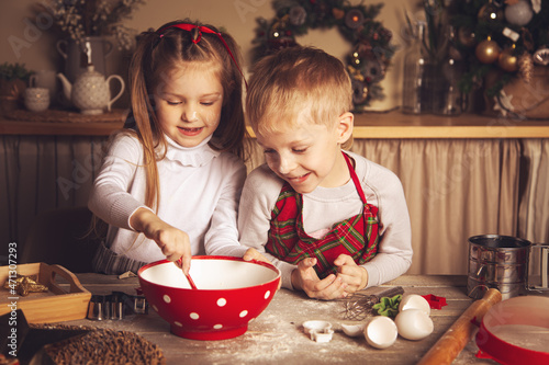 Children in the kitchen are preparing cookies.