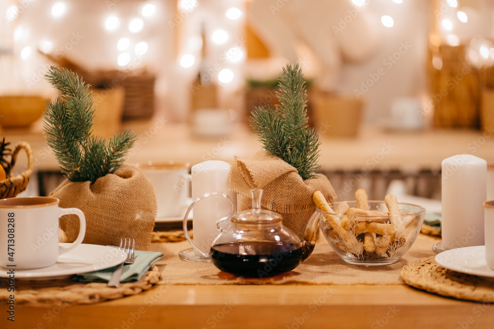 a teapot on the table in decorated kitchen for new year. electric garlands. a teapot on the table in decorated kitchen for new year. electric garlands.