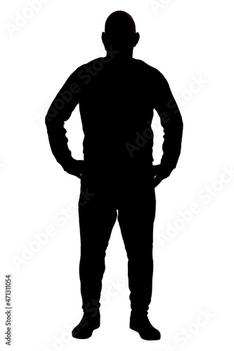 front view of the silhouette of a man wearing casual clothes with his arms on waist © curto