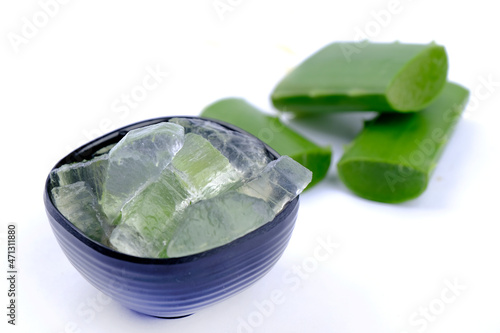 Close-up of organic green fresh aloe vera transparent gel in bowl, isolated over white, light passes through transparent gel, skincare product, Aloe vera cut into small pieces. photo