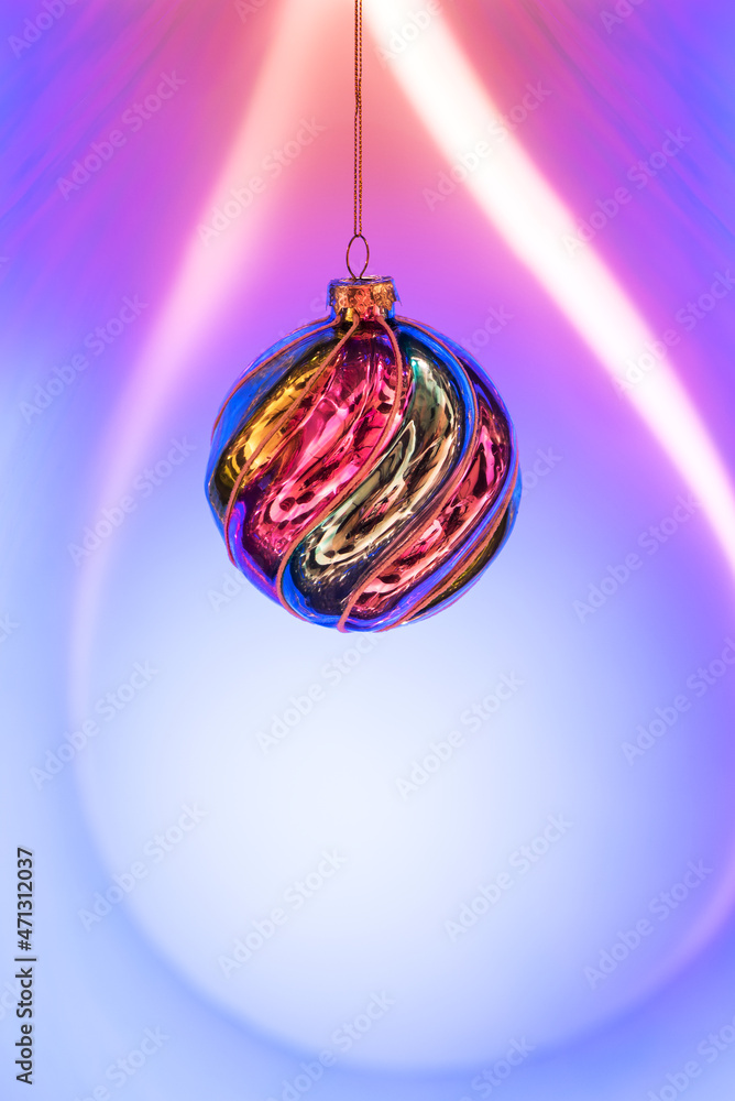 Fototapeta premium Christmas colorful ball hanging on a blue-purple background. Festive Christmas and New Year background with copy space. Banner
