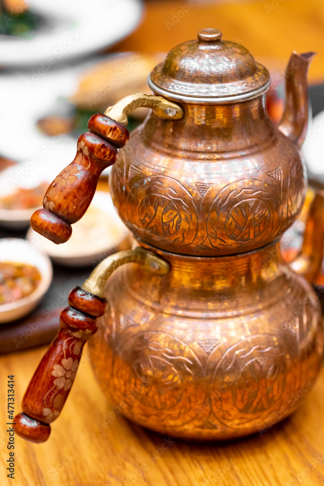 An engraved copper Turkish teapot with double teapots that allow you to brew tea in one, while hot water from the larger teapot is used to dilute individual cups of tea An engraved copper Turkish teapot with double teapots that allow you to brew tea in one, while hot water from the larger teapot is used to dilute individual cups of tea